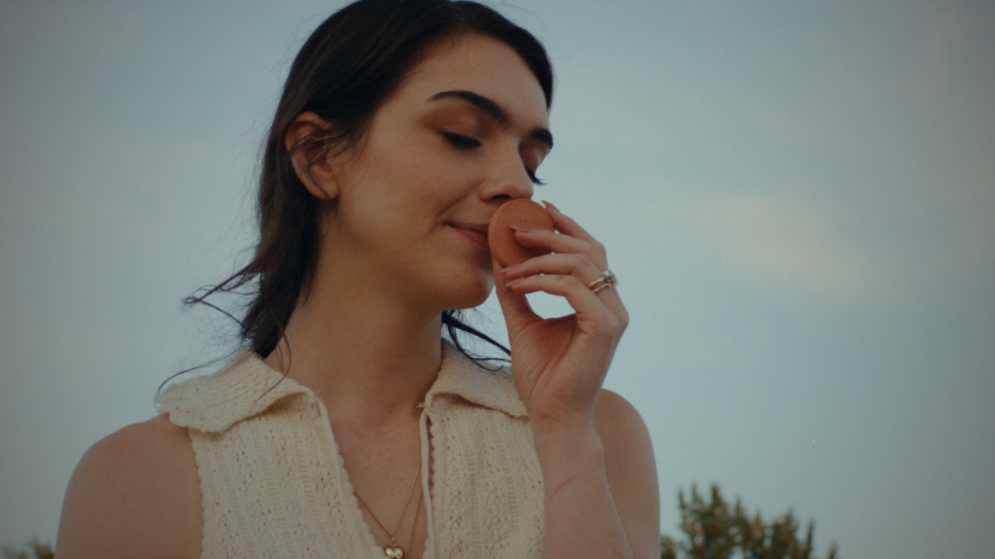 A woman pausing to smell a terracotta fragrance stone
