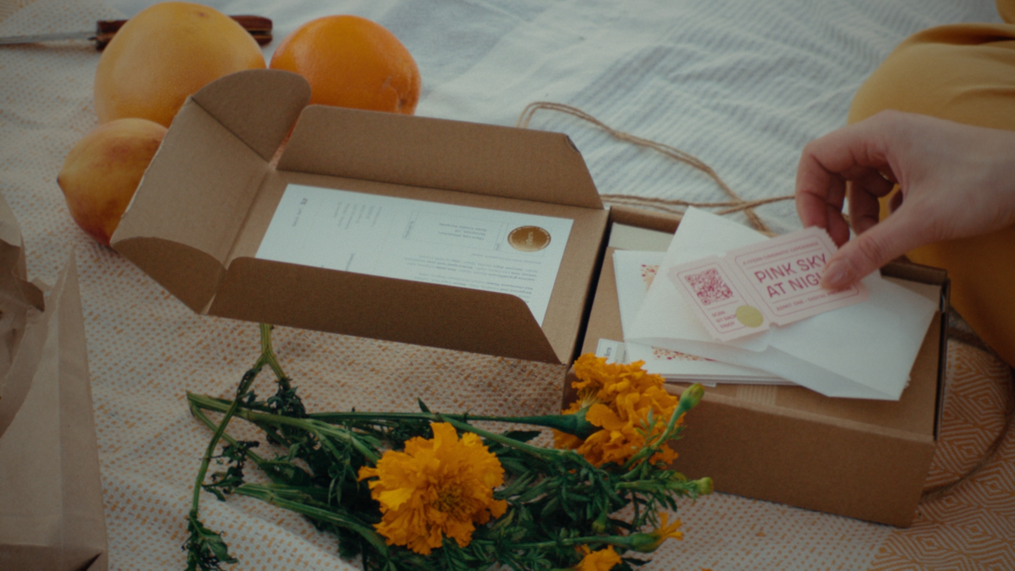 A summer fragrance parcel being opened among flowers and fruit