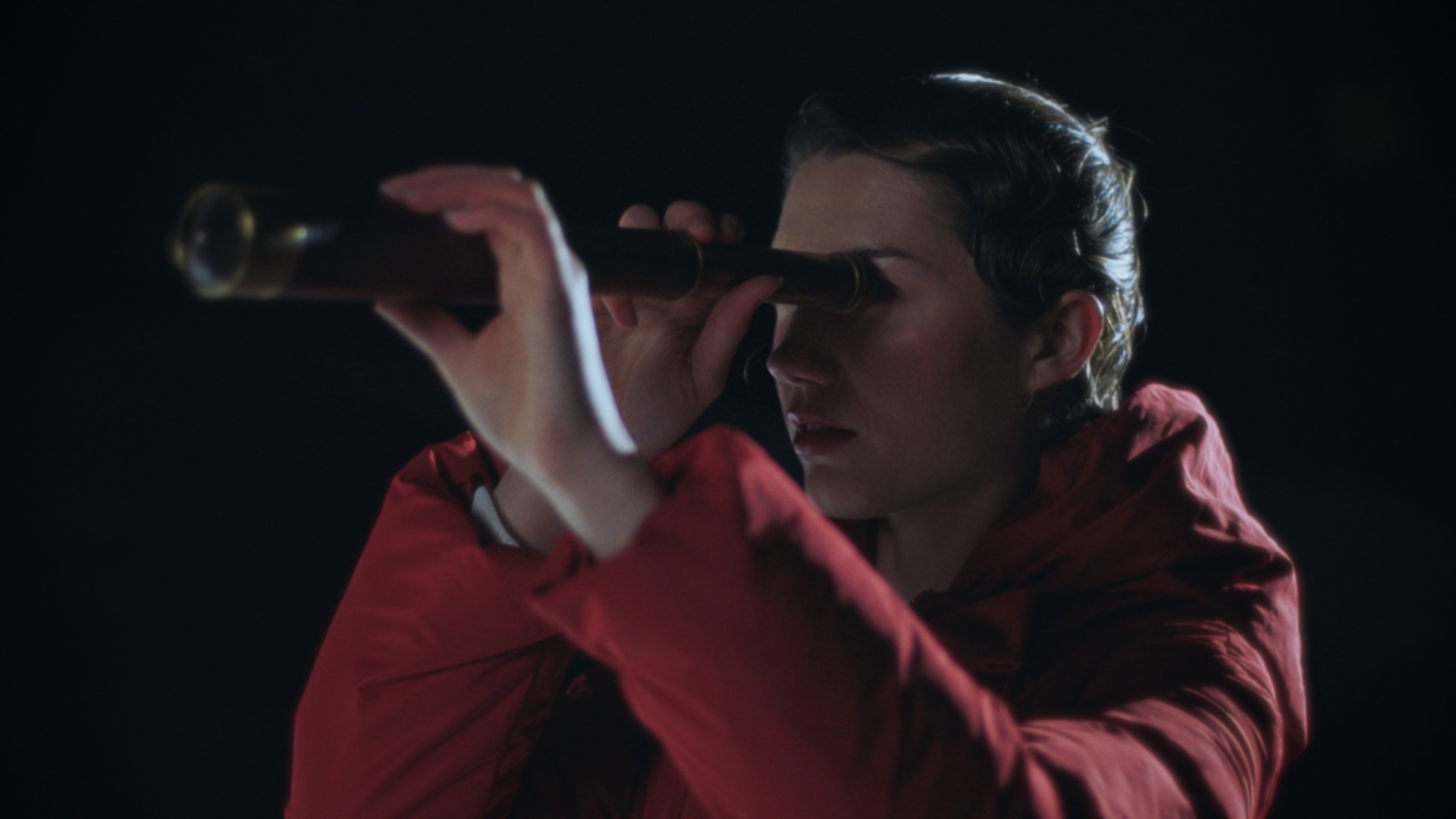 A woman looking through an antique brass telescope