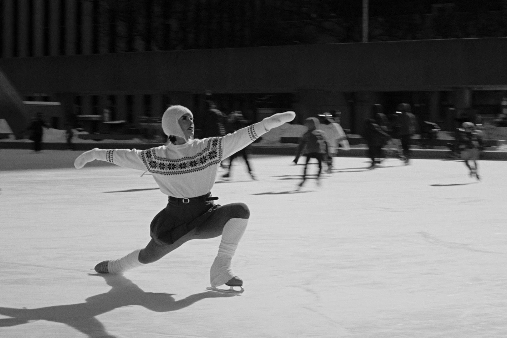 A figure skater holding a deep lunge across the ice