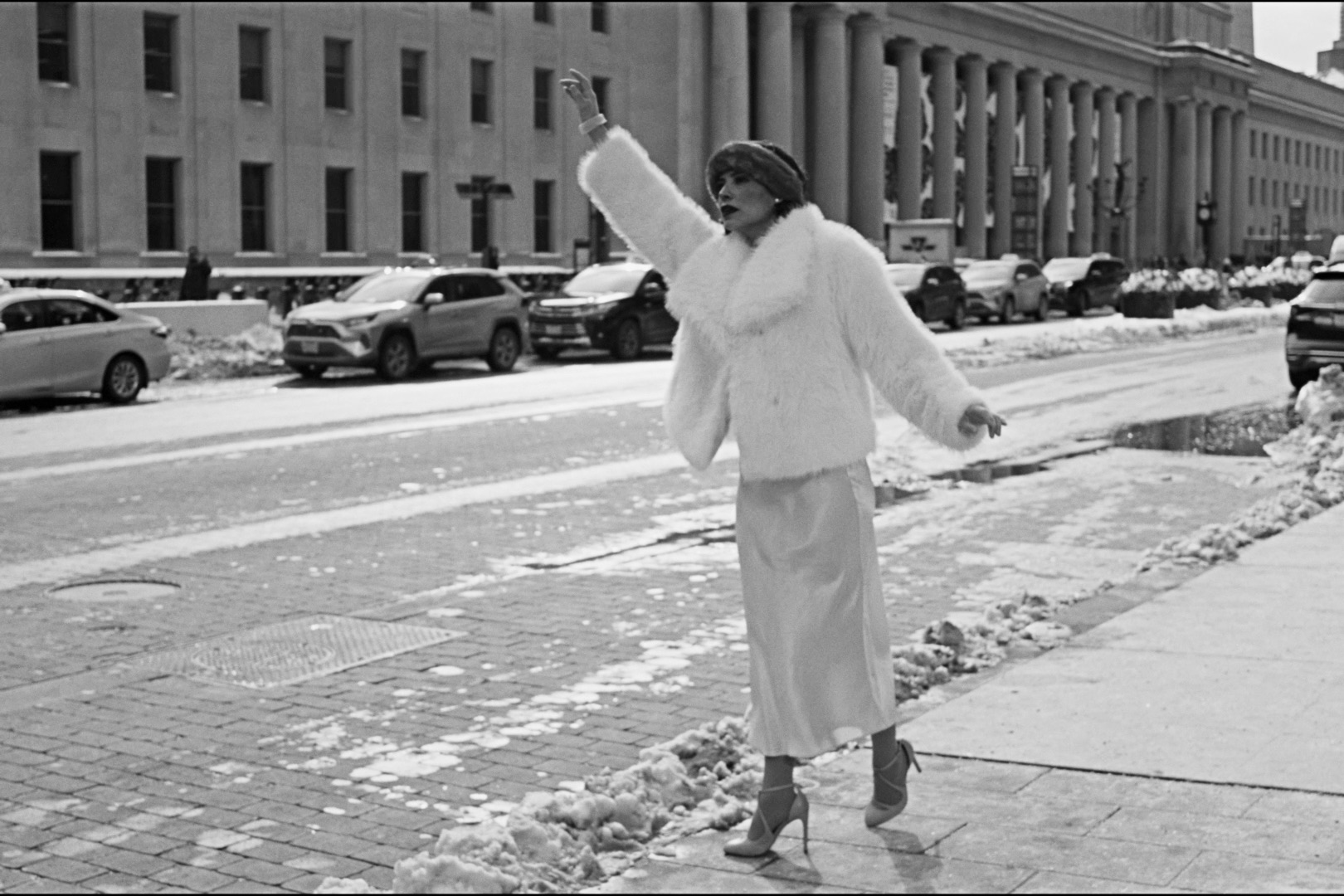 Gladys crossing a snowy city street in old-Hollywood styling